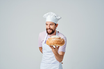a man in a chef's uniform with bread in his hands preparing food for professionals
