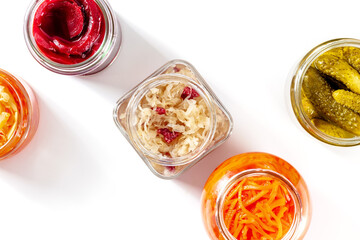 Fermented food on white. Canned vegetables. Pickled carrot, beet, sour cabbage and other organic preserves in glass jars, overhead flat lay shot with copy space