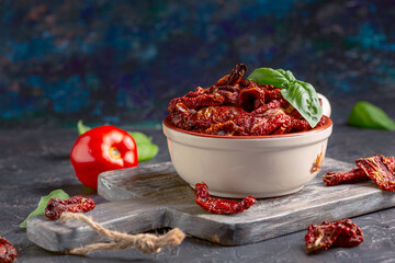 Bowl of dried tomatoes and fresh basil.
