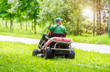 A man on a lawn mower in a city park