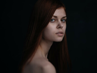 Fototapeta premium red-haired woman naked shoulders clear skin dark background