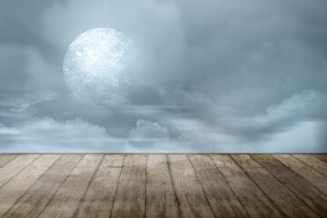 Wooden table with a full moon with dark cloudscapes on the night