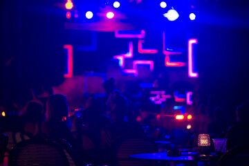 Scene with Neon lights . Group of happy womans  at concert in night club. Nigh  life concept .