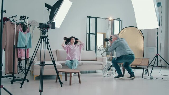 Male photographer is shooting a female model in the studio