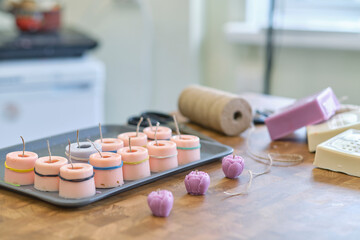 Decorative candles made of beeswax with a honey aroma. Handmade wax candle with ametyst crystal on light background. Christmas decoration for holidays. Craft and eco concept