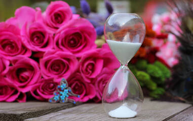 Vintage Hourglass With Pink Roses and Peacock Feathers Shallow DOF