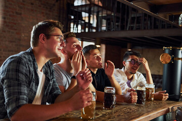 Soccer fans. People in casual clothes sitting in the pub