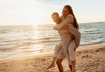 leisure and people concept - happy couple having fun on summer beach