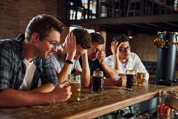 Soccer fans. People in casual clothes sitting in the pub