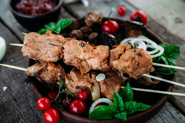 Pork shashlik on pita bread with vegetables close-up