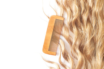 Wavy blond hair with bamboo comb isolated on white background top view