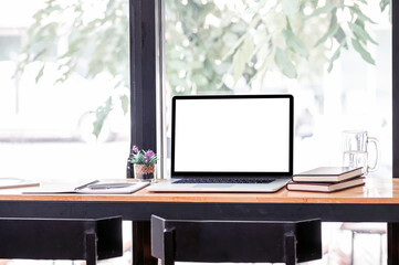 Mockup creative workspace with blank screen laptop computer on wooden counter table.