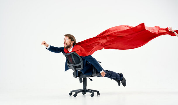 business man with red cloak trying in superman office chair