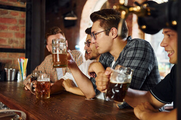 At daytime. People in casual clothes sitting in the pub