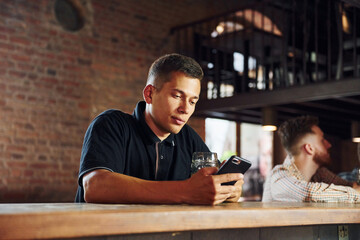 Beautiful interior. Man in casual clothes sitting in the pub
