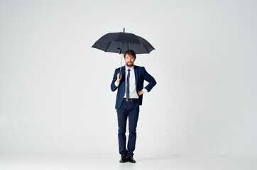 business man in a suit holding an umbrella elegant style protection from the rain