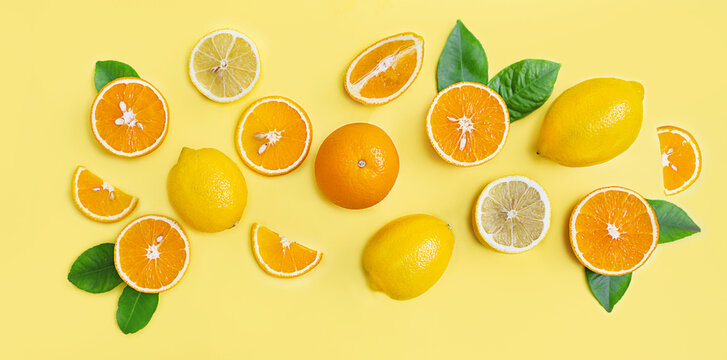 Composition of citrus lemons and oranges on a yellow background