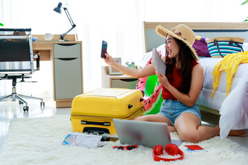 Young happy and excite Asian female traveler getting ready for a summer holiday trip vacation taking a selfie photo in bedroom
