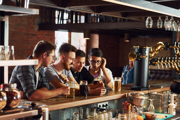 People in casual clothes sitting in the pub and drinking beer