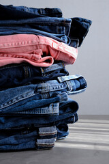 a pile of blue and pink jeans on a light background