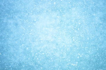 Glowing naturally blue ice with a haze effect with white patches of frost and frozen air bubbles. Background