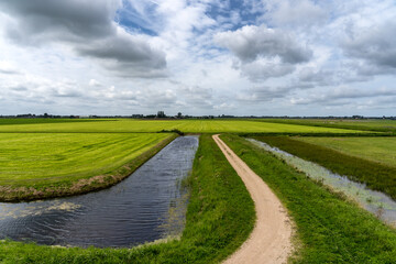 Polder landscape in Westfriesland (NL) with canal and clouds