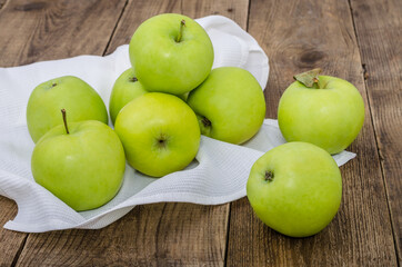 Green apples with napkin on the wooden table