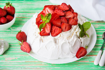 Pavlov's cake with strawberries and cream on a rustic background