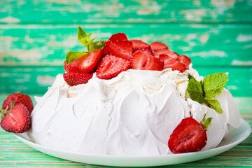 Pavlov's cake with strawberries and cream on a rustic background