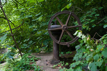 Una manivela oxidada de una presa en medio del bosque