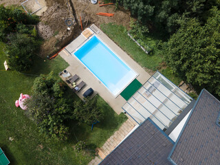 aerial drone flight of pool build construction site with pool filled with water in a garden
