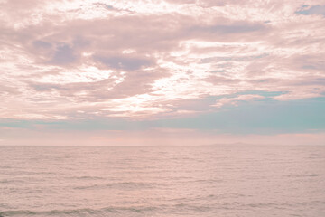 sunset over the sea with a pastel sky of pink.