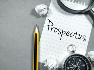 Business concept.Text Prospectus writing on notepaper with torn paper,pencil,compass and magnifying glass on gray background.