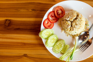 Crab meat fried rice and vegetable on a wooden table..