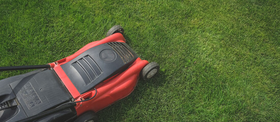 Lawn mower on green grass in a modern garden. Lawn Mowing Machine Gardening, Agriculture, Organic countryside, cottagecore.