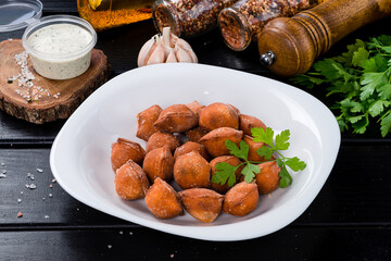 Traditional fried pelmeni, ravioli, dumplings filled with meat on black background, copy space.