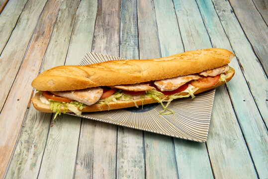 Huge Pork Tenderloin Sandwich With Tomato, Mayonnaise Sauce And Chopped Iceberg Lettuce