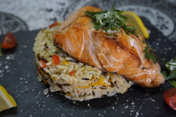 Delicious fried salmon fillet, seasonings on wild rice lemon slices and vegetables