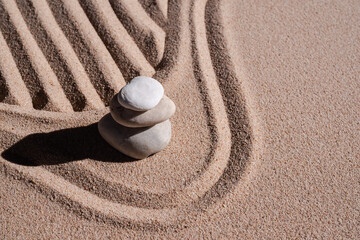 Fototapeta na wymiar Zen garden stone Japanese on raked sand. rock or pebbles on beach design outdoor for meditate peace of mind and relax. Buddhism religion concept.