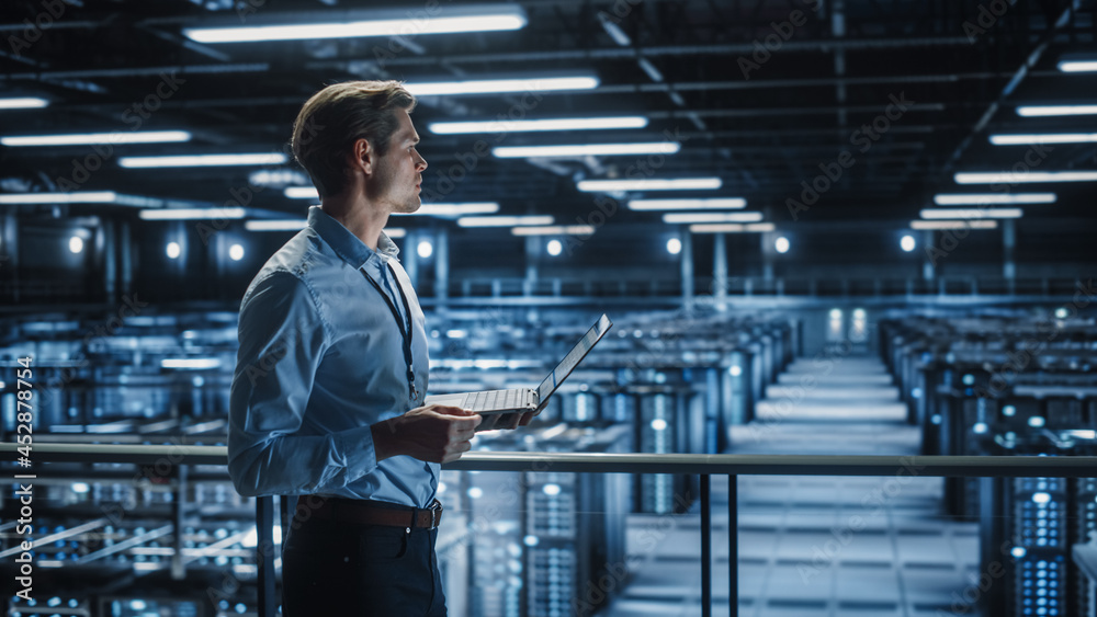 Aufkleber portrait of it specialist uses laptop in data center. server farm cloud computing facility with male