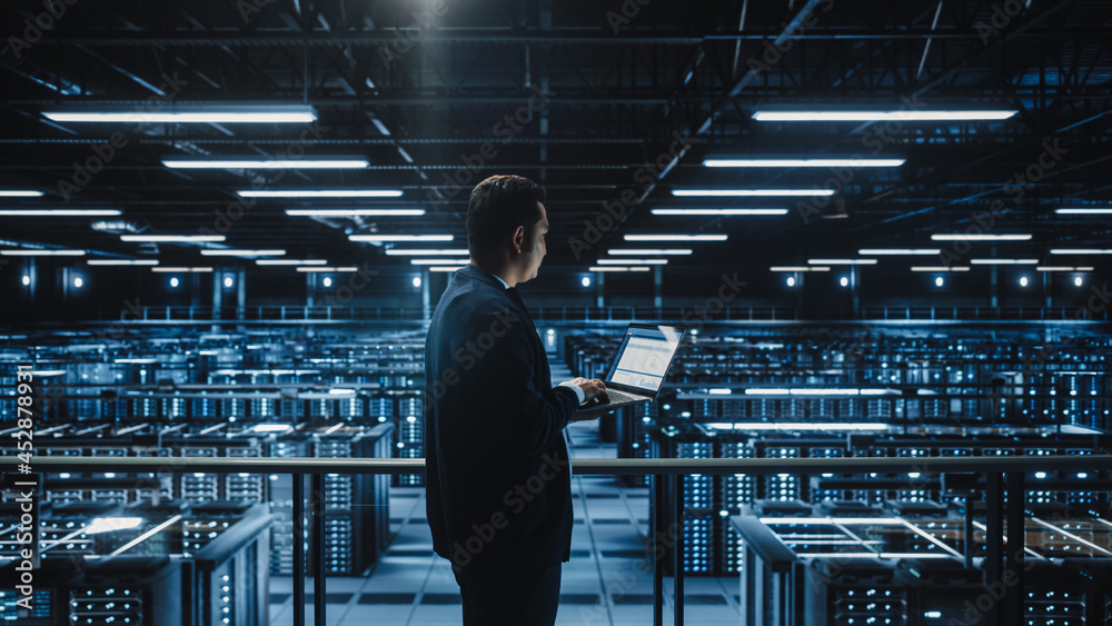 Aufkleber Data Center Male Administrator Using Laptop Computer. Maintenance Specialis working in Cloud Computing Facility on Cyber Security and Network Protection. Server Farm Analytics. Medium Wide
