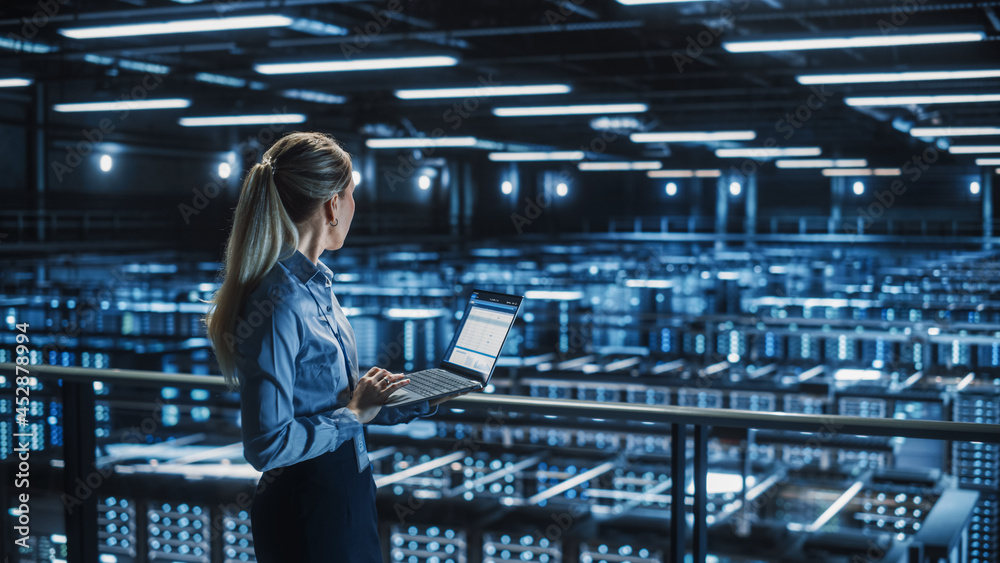 Leinwandbilder data center female it specialist using laptop. server farm cloud computing facility with beautiful m