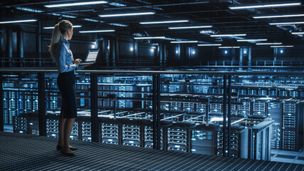Data Center Female It Specialist Using Laptop. Server Farm Cloud Computing and Cyber Security...