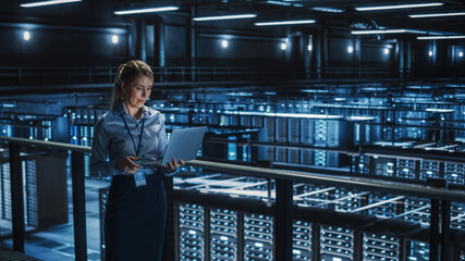 Data Center Female It Specialist Using Laptop. Server Farm Cloud Computing and Cyber Security...