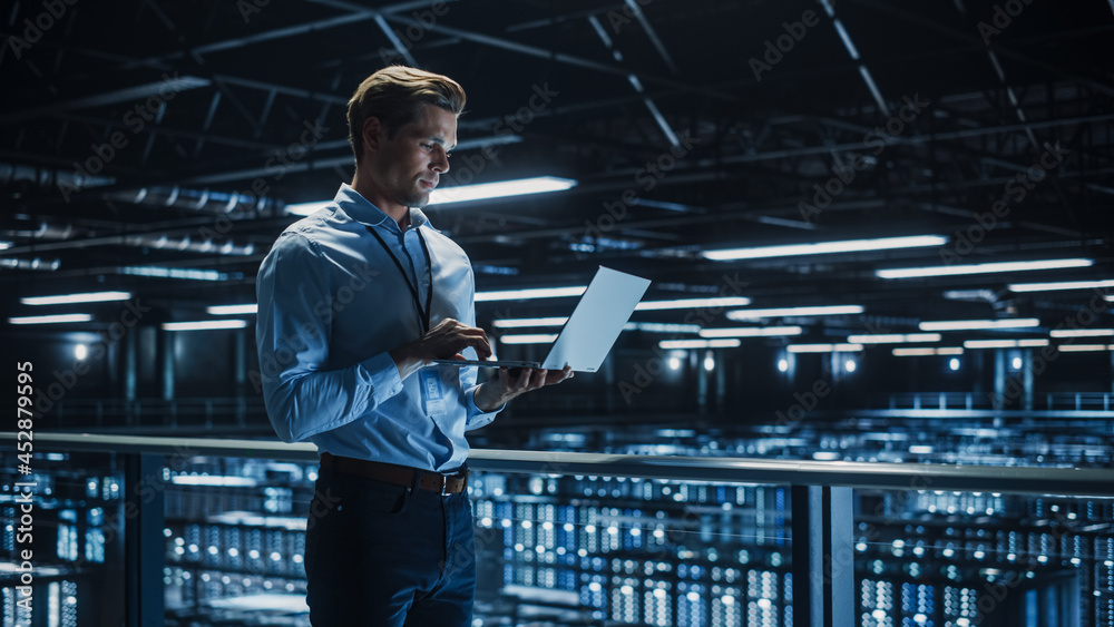 Aufkleber Handsome Smiling IT Specialist Using Laptop Computer in Data Center. Succesful Businessman and e-Business Entrepreneur Overlooking Server Farm Cloud Computing Facility.