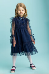 Lovely little girl posing in beautiful blue dress