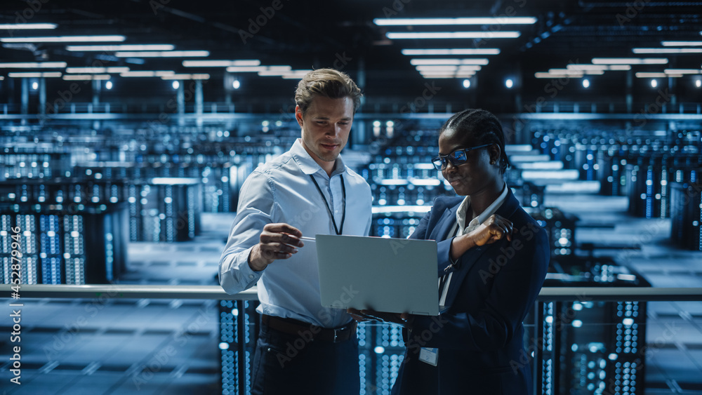 Leinwandbilder data center female system administrator and male it specialist talk, use laptop. information technol