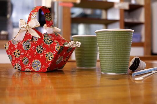 Nagano, Japan, 2021-10-08 , two paper cups filled with coffee, and aa red basket with sugar and cream.