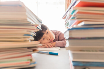 夏休みの大量の宿題に悩んでいる小学生の子供の様子