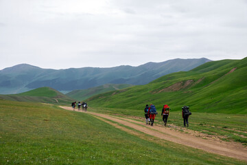 Fototapeta premium A group of backpackers are walking on mountain plateau. Travel, tourism concept. Nature landscape. Freedom journey.
